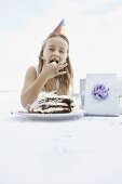 Young girl eating birthday cake