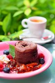 Chocolate souffle with summer berry sauce