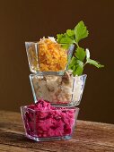 Three types of risotto in glass bowls stacked on top of one another