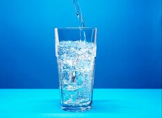 Mineralwasser ins Glas eingießen