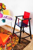 Retro-style dining room with high chair, colourful plastic chairs & long-pile rug