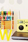 Laptop, radio and colourful arrangement on white desk