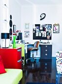 Modern work area with corner desk and swivel chair; spring green couch in foreground next to red chest of drawers