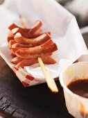 A barbecued sausage skewer with barbecue sauce