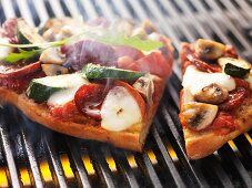 Sausage, vegetable and mozzarella pizza cooked on the barbecue