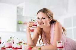 Junge Frau hält ein Glas Joghurt mit Beeren