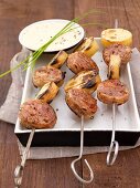 Andouillette kebabs (French sausage) and sliced potatoes, roasted pepper sauce as a side