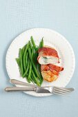 Chicken breast stuffed with blue cheese and wrapped in ham, served with green beans