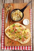 Tarte flambée with sour cream, cheese, onions and bacon