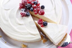 Cheesecake with berries, one slice cut (view from above)