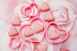 pink chocolate love hearts with heart shaped cookie cutters on a pastel rose pattern