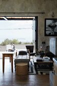 Blick vom Wohnzimmer mit Wänden im Shabby Look auf die Terrasse und auf das Meer