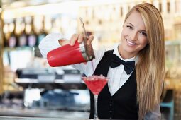 Kellnerin mixt Cocktail im Restaurant