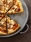 Sliced Mushroom Pizza on a Pizza Pan with a Slice Removed