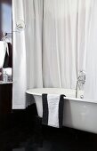 Black and white bathroom with bathtub and shower curtain