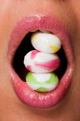 Three sweets, stacked and held between the teeth