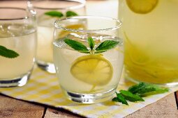Hausgemachte Limonade mit Zitronenscheiben und Minzeblättchen