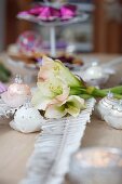 Christmas table centrepiece of white amaryllis and baubles