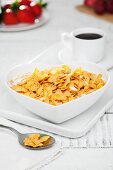 Cornflakes with milk in a heart-shaped bowl