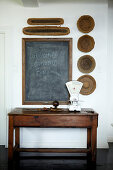 Blackboard for shopping lists and wooden bowls decorating wall above retro kitchen scales on old, rustic table