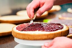 A sponge cake being spread with jam