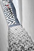 Staircase with traditional, Moroccan-style patterned tiles merging into modern, graphic, black and white pattern of courtyard floor tiles