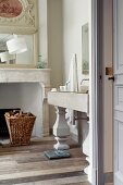 Washstand with column-style legs next to open fireplace in traditional, elegant bathroom
