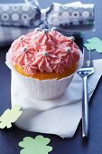 A cupcake decorated with pink cream for New Year's Eve