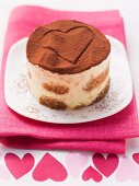 Individual tiramisu with a heart shape in cocoa powder