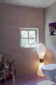 Postmodern inspired bathroom with designer lamp and acrylic chair with concrete walls and pastel violet floor