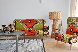 Sofa and chair upholstered in eye popping Kilim, wicker floor lamp; table and rug in shades of gray