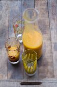 Mango smoothie in a glass and in a carafe