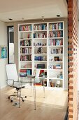 Moderner Arbeitsplatz - Glastisch mit Metallgestell und weisser Bürostuhl vor weissen Bücherregalen an Wand