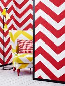 Mini-room with red and white zigzags on the movable walls and yellow and white zigzag armchair