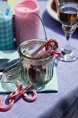 Candy canes, colourful candles and a drink on a table