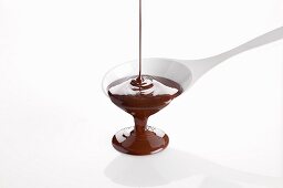 Melted chocolate pouring from a cooking spoon