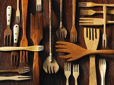 Assorted wooden forks on a wooden surface