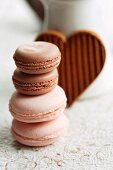 Assorted macaroons in front of a heart-shaped chocolate biscuit
