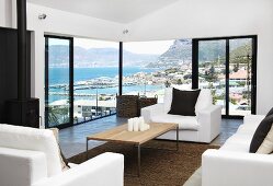 Interior with panoramic view of mountainous coastline - wood-topped coffee table and white sofa set