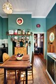 Turquoise, traditional-style kitchen with pots and pans hanging over wooden cabinet