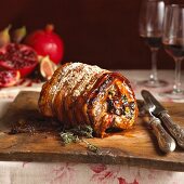 Rolled stuffed roast pork on a chopping board