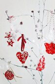 Red sweeties hanging on cherry branches spray-painted white