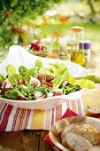 Sommersalat mit Feigen und Erdbeeren auf einem Tisch im Freien