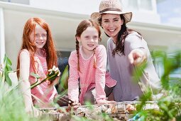 Mother and daughters gardening