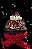Schokoladen-Cupcake mit rotem Wollschal zu Neujahr