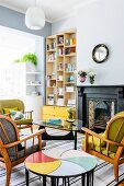 Retro seating area with original side tables; modern bookcase and bright yellow drawers in niche