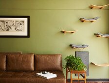 Hand-crafted wooden shelves as sleeping areas for cats next to leather couch in living room