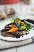 Beef fillet with glazed carrots and black garlic