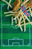 Fish and chips (England) with a paper Union Jack flag and football-themed decoration