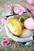 Eggs painted in pastel colours for Easter in a small basket